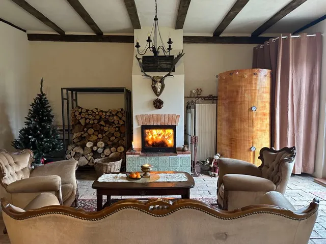 The barn gathering room with its traditional furnace, heavy timber beams and rustic decor